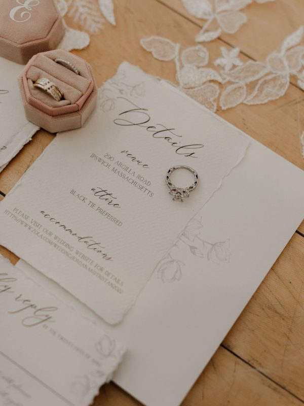 beautiful neutral wedding invitation flat lay with wedding rings