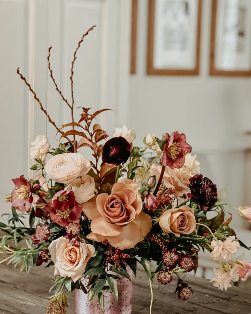 beautiful romantic floral arrangement with shades of pink in a frosted pink vase