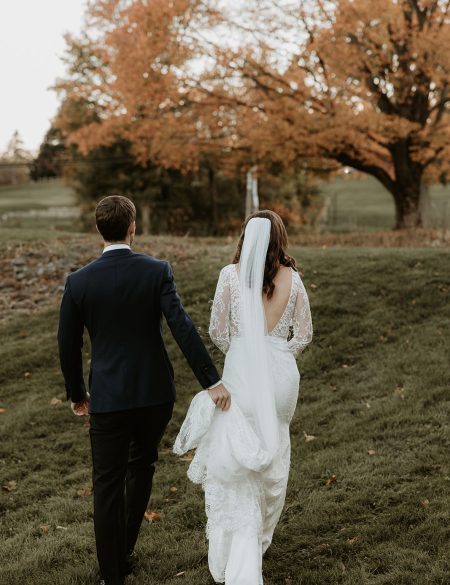 gorgeous outdoor fall wedding with bride and groom walking in a field